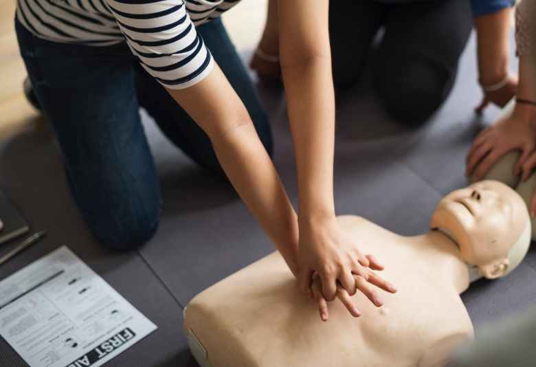 person performing cpr on dummy